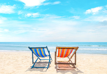 Two beach chairs on white sand, blue sky and summer sea background. Summer concept, holiday, travel, text input area 