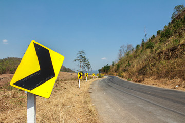Yellow traffic signs warning for dangerous curve way with asphalt road