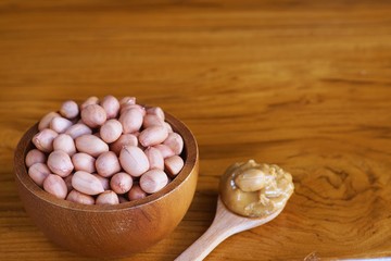 Fototapeta na wymiar Peanut in wooden bowl on classic wooden table background, peanut butter
