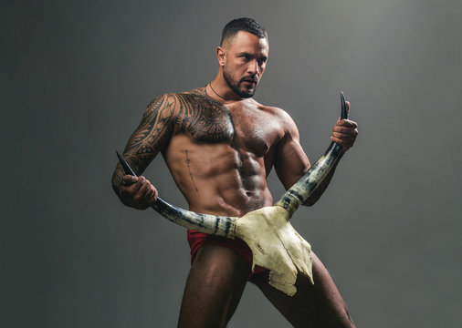 Desire is the energy force. Sexy latino man showing his sexual desire and attraction. Muscular hispanic man with fit body holding skull and horns. Attractive power and desire force. Desire concept