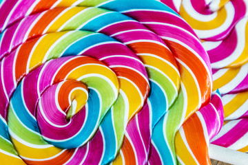 Fototapeta na wymiar striped spiral multi-color Lollipop closeup. sweets multicolour