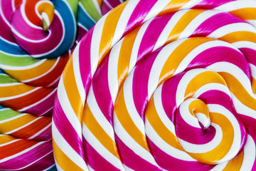 Fototapeta na wymiar striped spiral multi-color Lollipop closeup. sweets multicolour