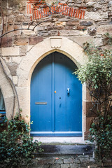 Fototapeta na wymiar Beautiful old blue door and a pointed stone arch 