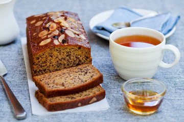 Banana, carrot, apple cake, loaf with chocolate and cup of tea on grey background.
