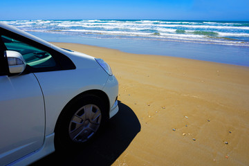 Car facing the sea on the beach. ビーチで海と向かい合う自動車