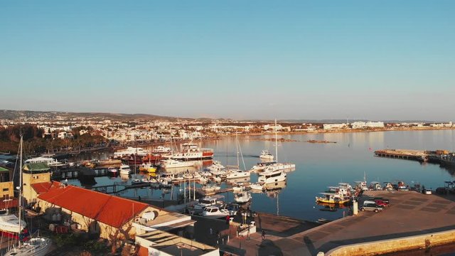 Drone fles over paphos city marina harbor bay with yachts, motorboats, ships and fish industrial boats floating near pier.