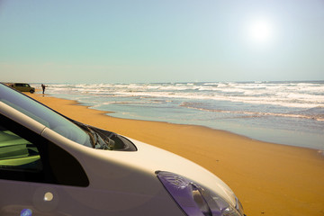 Car facing the sea on the beach. ビーチで海と向かい合う自動車