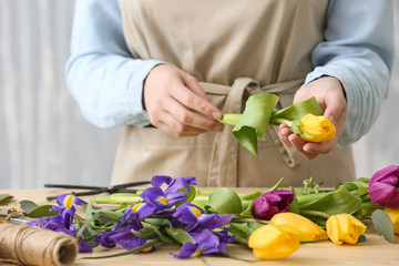 Obraz na płótnie Canvas Florist making beautiful bouquet at table, closeup