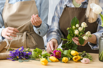 Florists making beautiful bouquet at table