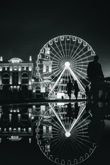 Fototapeta premium People siluette in front of Black and white Ferris wheel at European night. Kyiv, Ukraine