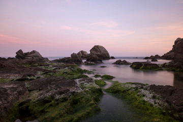 Fototapeta na wymiar Beach and rocks at sunset in Lloret de Mar