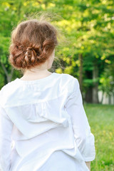 Young woman wearing white shirt looking at the high trees in deep forest