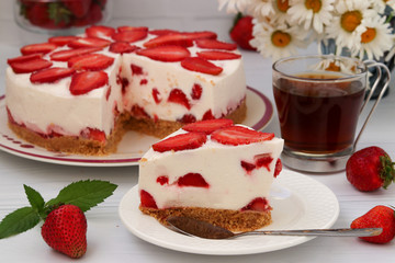 Cake with strawberries without baking located on a plate on a white background