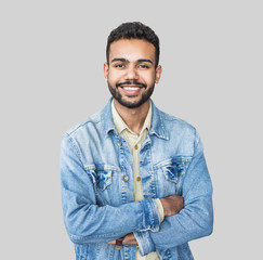 Portrait of handsome smiling young man with folded arms. Laughing joyful cheerful men with crossed hands studio shot. Isolated on gray background