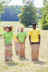 Obraz premium Junge Leute beim Sackhüpfen Wettkampf