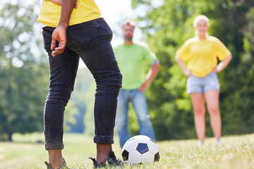 Junge Leute spielen Fußball auf einer Wiese