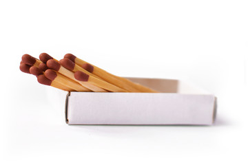 Multiple wooden matchsticks with brown heads in box isolated on white background