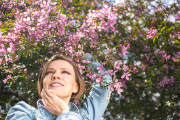 Fototapeta premium gorgeous girl in blossom spring garden enjoying and relaxing