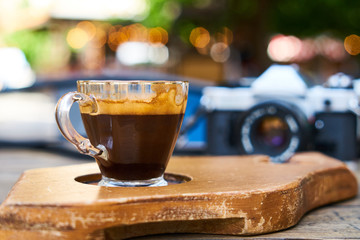 Dark espresso coffee and retro film camera