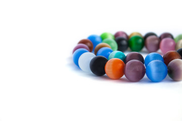 Cat's eye quartz necklace and bracelet, selective focus on white background isolated. Colourful precious stones.