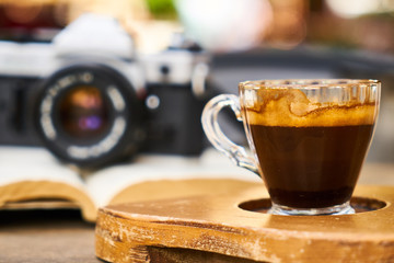 Dark espresso coffee and retro film camera