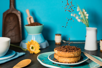 falling chocolate sprinkles (Dutch hagelslag) on rusk. Against blue background