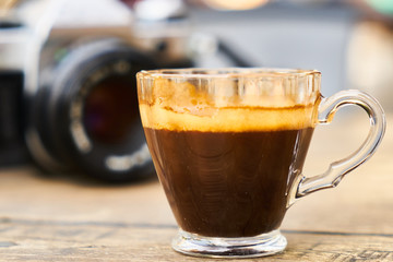 Dark espresso coffee and retro film camera