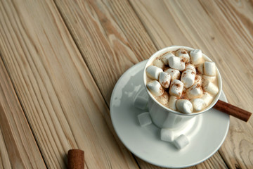 Fototapeta na wymiar Hot morning coffee with marshmallow and cinnamon on a wooden stand, top view
