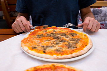 man eating pizza in restaurant