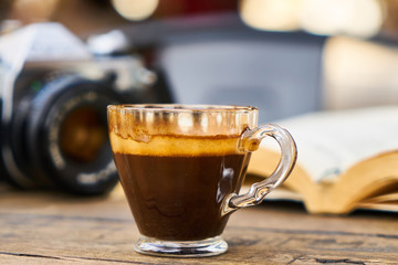 Dark espresso coffee and retro film camera