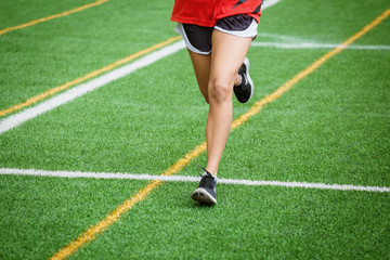young sport girl running on sport field