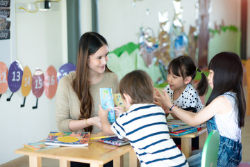 teacher and group of international kids in classroom attending and enjoy learning together