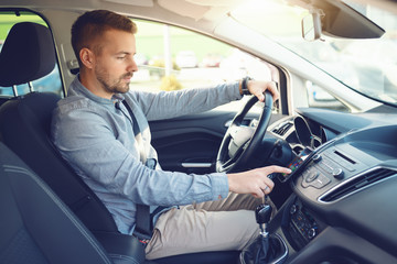 Caucasian man turning on navigation on smart phone while sitting in his car.