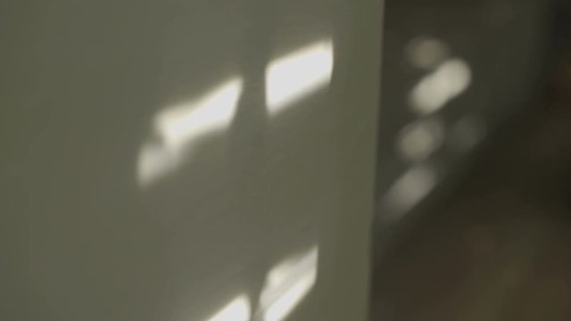 Electric window shutters being opened - moving shadows on the wall