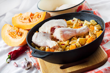 Cooking one-pot meal - chicken thighs and legs with potatoes and pumpkin