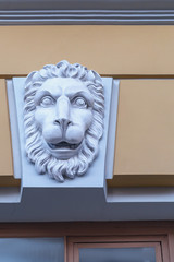 plaster sculpture of a lion's head on the facade of a building in the Russian city of St. Petersburg