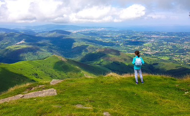 Fototapeta premium Girl standing with her back to see the landscape from Mount Larrun. Demarcation between the border of Spain and France in the Pyrenees.