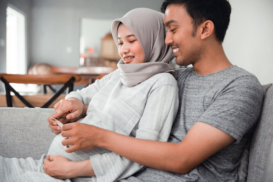 couple looking at ultrasound images in livingroom together