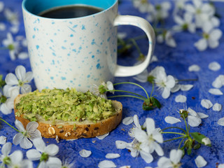 A Cup of espresso and a sandwich with finely chopped avocado