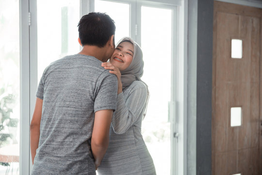 husband and wife muslim kissing each other at home
