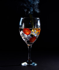 Glass with ice, fruit and smoke