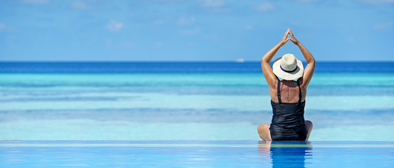 Ältere Frau am Strand beim Yoga