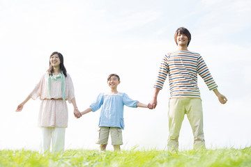 草原で手をつなぐ家族