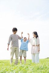 草原で手をつなぐ家族
