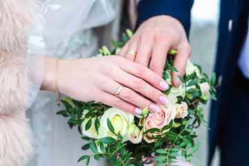 wedding rings hands newlyweds on a wedding bouquet