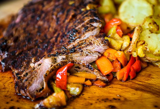 Sliced Grilled Juicy Marinated Beef Flank Steak On Wooden Board.