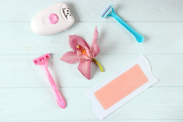 A set of different hair removal products on a wooden table. Removal of unwanted body hair at home.
