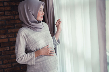 muslim pregnant woman asian looking at the window