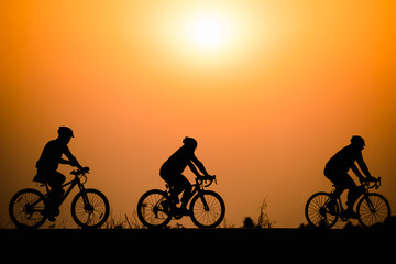 Fototapeta premium Silhouette man cycling on sunset background