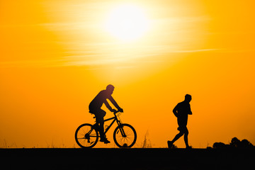 Fototapeta na wymiar Silhouette man cycling on sunset background
